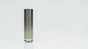 une pile alcaline rechargeable sur fond blanc brillant avec reflet. fermez une batterie vide avec un espace de copie. photo