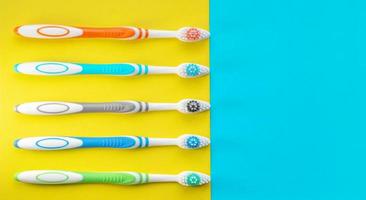 brosses à dents multicolores sur fond bleu et jaune. la vue d'en haut. fermer. photo