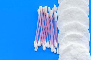 tampons de coton et bâtonnets de coton sur fond bleu avec une place pour l'écriture. le concept de soins du corps. photo