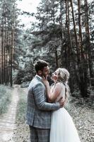 les mariés s'embrassent dans la forêt le jour du mariage. cérémonie de mariage. mise au point sélective. grain de film. photo