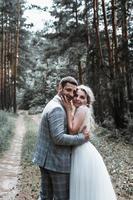 les mariés s'embrassent dans la forêt le jour du mariage. cérémonie de mariage. mise au point sélective. grain de film. photo