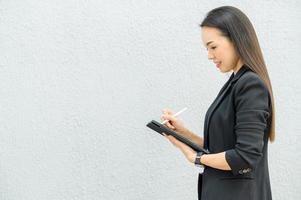 femme de travail asiatique tenant une tablette au bureau femme de travail concept femme d'affaires avec la technologie photo