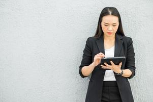 femme de travail asiatique tenant une tablette au bureau femme de travail concept femme d'affaires avec la technologie photo