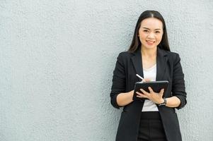 femme de travail asiatique tenant une tablette au bureau femme de travail concept femme d'affaires avec la technologie photo