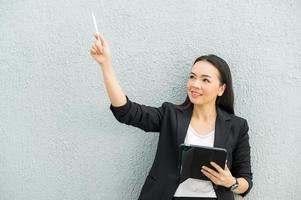 femme de travail asiatique tenant une tablette au bureau femme de travail concept femme d'affaires avec la technologie photo