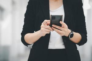 femme au travail asiatique tenant un téléphone portable debout au bureau concept de femme d'affaires femme d'affaires dans la technologie de la classe photo