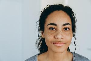 femme noire souriante et regardant de côté pendant qu'elle passe du temps à la maison photo