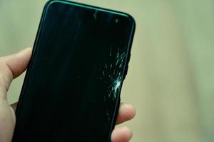écran de verre cassé de smartphone à la main - écran cassé de téléphone portable attendre changer l'écran de film dans le concept d'atelier de réparation photo