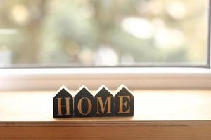 décor à la maison de nature morte dans une maison confortable avec des lettres en bois avec l'inscription home. le concept de décor et de confort. mise au point sélective photo