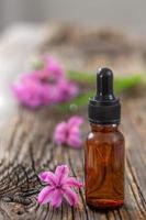 bouteille d'huile essentielle de jacinthe rose et fleur sur fond de bois photo