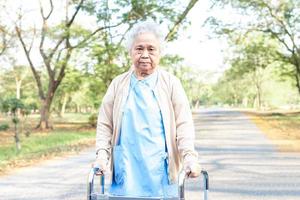 Une patiente asiatique âgée ou âgée d'une vieille dame marche avec un marcheur dans un parc, un concept médical solide et sain photo