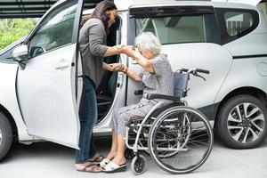 aidez et soutenez une patiente asiatique âgée ou âgée, assise sur un fauteuil roulant, se prépare à se rendre à sa voiture, concept médical solide et sain. photo