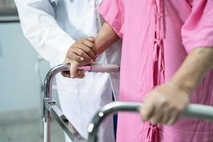 Une patiente asiatique âgée ou âgée marche avec une marchette dans un hôpital de soins infirmiers, un concept médical solide et sain photo