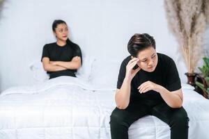 une femme qui s'aime se fâche et s'assoit sur le lit. photo