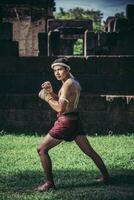 un boxeur a attaché une corde dans sa main et a effectué un combat, les arts martiaux du muay thai. photo