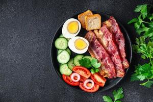 petit déjeuner anglais bacon, oeuf, tomate, concombre, pain grillé photo