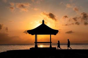 couple silhouette marchant vers le pavillon avec le lever du soleil qui brille photo