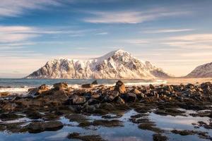 lever du soleil sur la montagne enneigée sur la côte de la plage de skagsanden photo