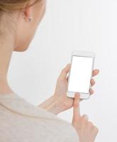 portrait d'une femme tapant sur un téléphone portable isolé sur fond blanc. écran blanc pour le mettre sur votre propre page Web ou message