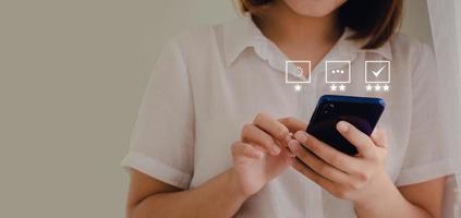 une femme d'affaires évaluant le service client par téléphone dans une idée d'entreprise avec une icône apparaissant à l'écran en attente de chargement de la bonne réponse photo