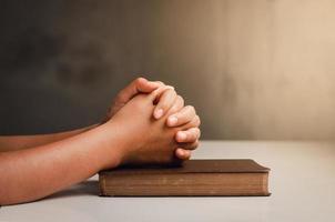 crise de la vie chrétienne priez Dieu les hommes priez pour une bénédiction de Dieu pour une vie meilleure. la main de l'homme priant Dieu avec la bible. croire au bien une poignée de prières sur une table en bois