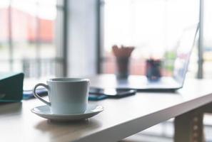 tasse à café blanche sur table de travail photo