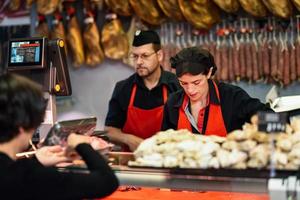 bouchers s'occupant d'un client dans une boucherie photo