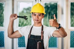 un technicien tient un tournevis et tient un pouce. photo