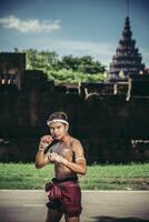 un boxeur a attaché une corde dans sa main et a effectué un combat, les arts martiaux du muay thai. photo