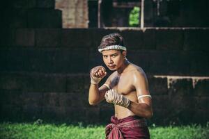 un boxeur a attaché une corde dans sa main et a effectué un combat, les arts martiaux du muay thai. photo