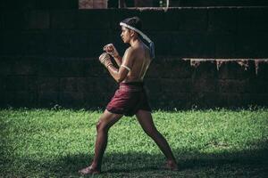 un boxeur a attaché une corde dans sa main et a effectué un combat, les arts martiaux du muay thai. photo