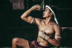 un boxeur a attaché une corde dans sa main et a effectué un combat, les arts martiaux du muay thai. photo