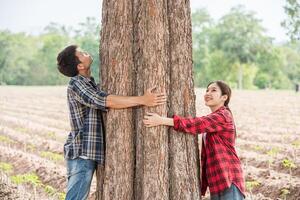 hommes et femmes debout et serrant les arbres. photo