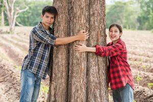 hommes et femmes debout et serrant les arbres. photo