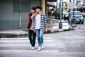 deux jeunes hommes aimants en chemises et marchant dans la rue. photo