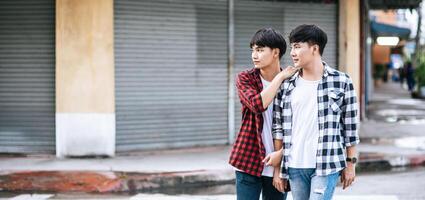 deux jeunes hommes aimants en chemises et marchant dans la rue. photo