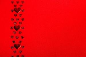 coeurs rouges de différentes tailles sur un fond texturé rouge. espace de copie de bannière festive de la saint valentin et de la fête des mères photo