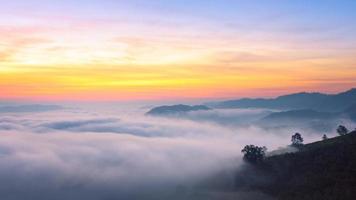vue panoramique sur la brume étonnante se déplaçant sur les montagnes naturelles pendant le lever du soleil dans la région des montagnes en thaïlande. photo