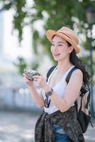 belle femme touristique asiatique aime prendre une photo avec un appareil photo rétro sur un site touristique. voyage de vacances en été.