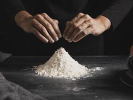 vue de face mains de boulanger mélangeant la farine