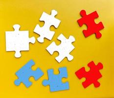 pièces colorées d'un jeu de puzzle sur fond jaune. prise de vue en studio