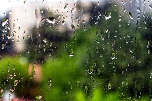 gouttes de pluie sur une vitre avec des arbres verts en arrière-plan. mise au point sélective. photo