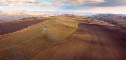 Vue panoramique aérienne du paysage de la zone protégée du parc national de Vashlovani avec jeep sur la route passig au premier plan photo