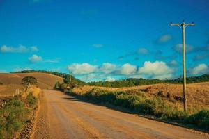 chemin de terre déserte traversant des plaines rurales appelées pampas et bétail près de cambara do sul. une petite ville de campagne dans le sud du brésil avec des attractions touristiques naturelles étonnantes. photo retouchée.