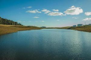 lac d'eau bleue sur le paysage des plaines rurales appelées pampas avec des buissons secs couvrant les collines près de cambara do sul. une petite ville de campagne dans le sud du brésil avec des attractions touristiques naturelles étonnantes. photo