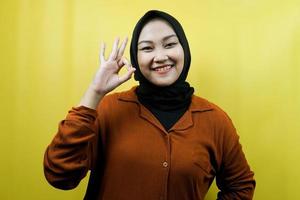 belle jeune femme musulmane asiatique avec les mains signe ok, succès, bon travail, signe de réussite, souriant confiant, enthousiaste et joyeux, isolé photo