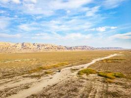 Vue panoramique aérienne du paysage de la zone protégée du parc national de Vashlovani avec jeep sur la route passig au premier plan photo