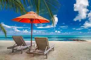 beau paysage d'île tropicale, deux chaises longues, chaises longues, parasol sous palmier. sable blanc, vue mer avec horizon, ciel bleu idyllique, calme et détente. hôtel balnéaire inspirant