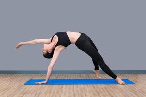 une jeune femme asiatique aime pratiquer la pose de yoga dans une salle de sport saine, le yoga et la méditation ont de bons avantages pour la santé. concept photo pour le yoga sport et mode de vie sain