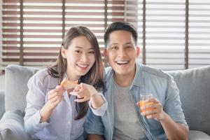 les amoureux des couples asiatiques aiment regarder des divertissements en streaming sur Internet via une télévision intelligente pour rester en sécurité à la maison photo